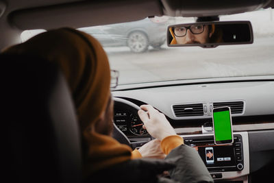 Millennial man drive the car and using mobile app , green screen. high quality photo