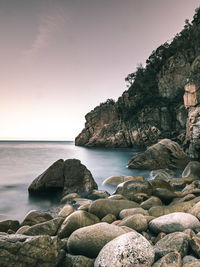 Rocks in sea against clear sky