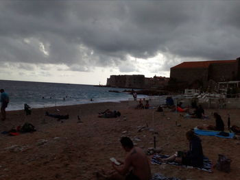 People on beach against sky