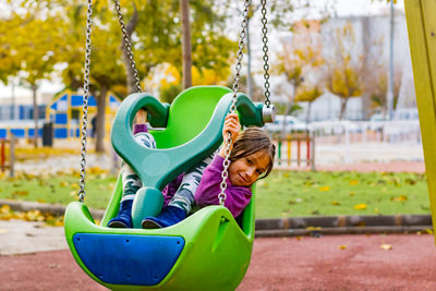 Girl playing with swing in park