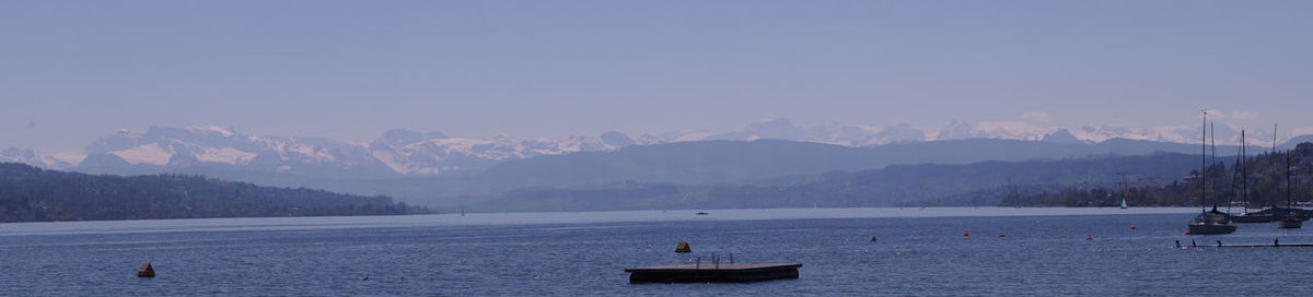 Scenic view of sea and mountains against sky