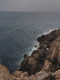 Rock formations by sea against sky