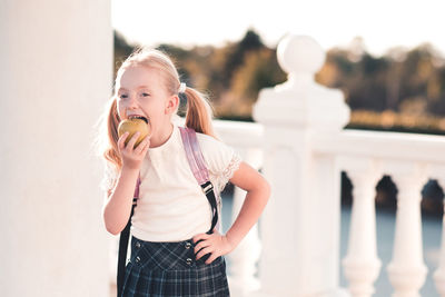 Portrait of cute girl eating apple