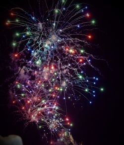 Low angle view of firework display at night