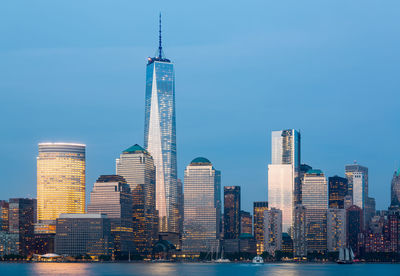 Illuminated lower manhattan buildings by hudson river