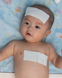 Portrait of cute baby boy on bed