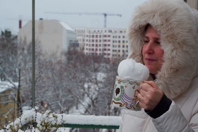Full length of man holding ice cream during winter