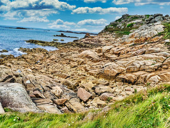 Scenic view of rocks on beach against sky