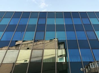 Low angle view of office building against blue sky