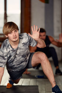 Man gesturing while exercising at yoga studio