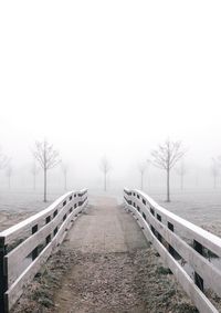 Snow covered field against sky during foggy weather