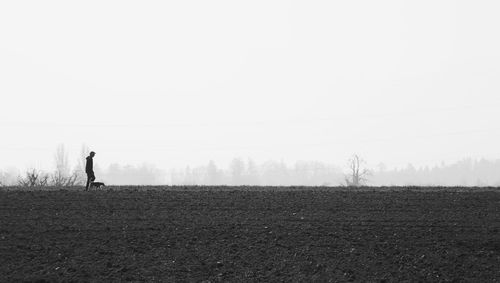 Silhouette man standing on field against sky