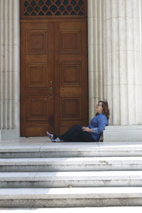 Side view of thoughtful woman relaxing outside building