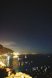 Illuminated cityscape against sky at night