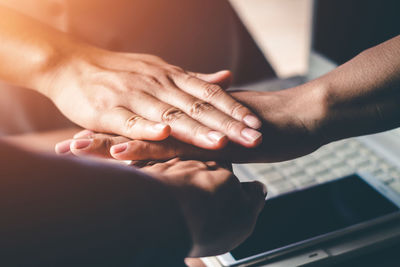 Cropped image of people stacking hands