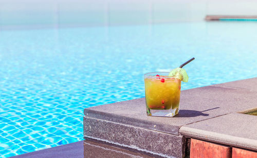 Drink on table by swimming pool