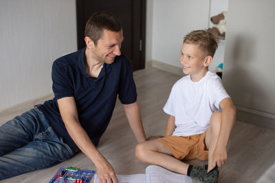 White t-shirt, electrical designer, lots of details, boy and man, dad and son, sit on the floor