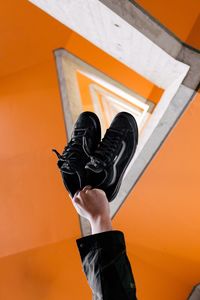 Low section of man wearing orange shoes