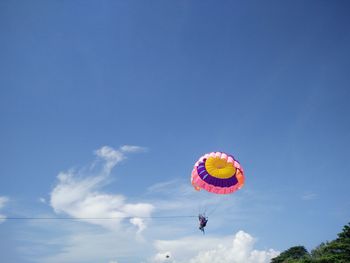 Low angle view of colorful balloons against blue sky