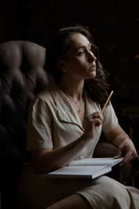 Young woman talking while holding pen