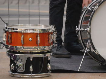 Low section of man standing by drums on stage