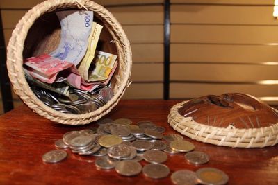 Close-up of coins and paper currency with container on table