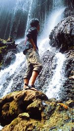 Full length of man splashing water in river