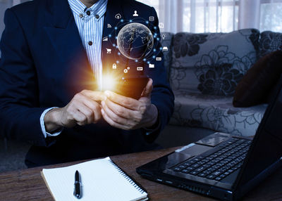 Midsection of businessman using laptop