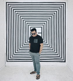 Full length of young man standing against door