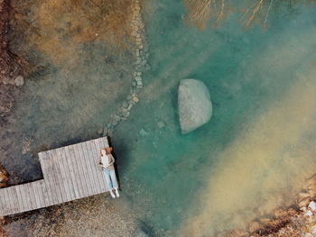 High angle view of woman on a rack at a pond