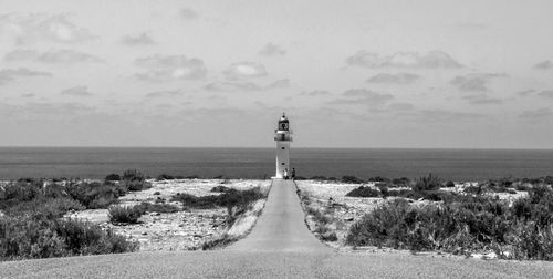 Lighthouse by sea against sky