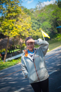 Portrait of young woman standing on road