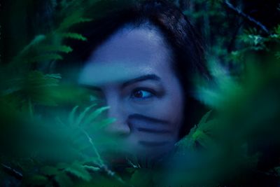 Close-up portrait of young woman in forest