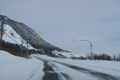 Snow covered road against sky