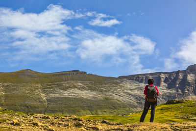 Rear view of mature woman standing against mountains