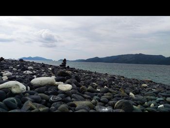 Pebbles on beach against sky