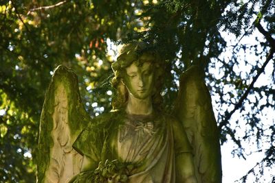 Low angle view of statue against trees