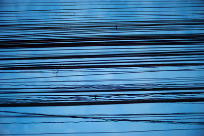 Low angle view of cables against blue sky