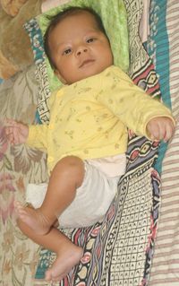 High angle portrait of cute baby on bed