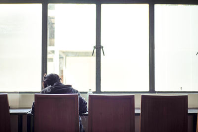 Rear view of people sitting on table