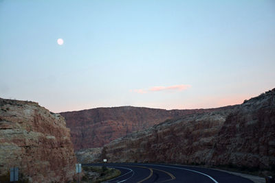 Road by mountains against sky at night