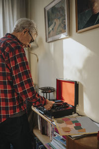 Senior man using gramophone at home