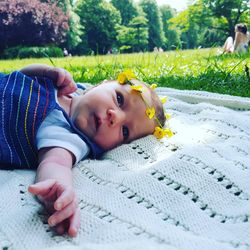 Close-up of cute baby lying on picnic blanket