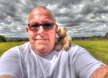 Portrait of smiling man wearing sunglasses against sky
