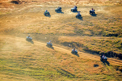High angle view of people riding quadbikes on field