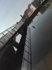 Low angle view of bridge and buildings against sky