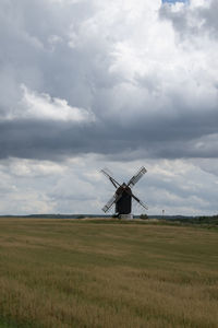 Windmill on field against sky