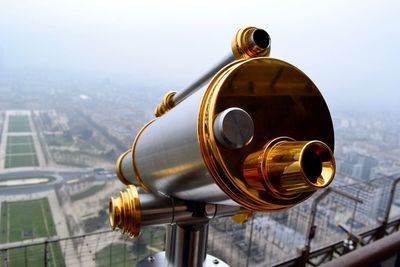 Gilded coin-operated binoculars at observation point with landscape in background