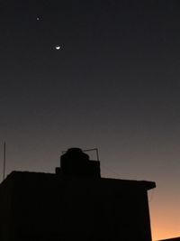 Low angle view of silhouette buildings against sky at night