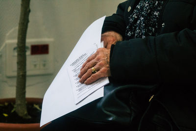 Midsection of senior woman holding documents
